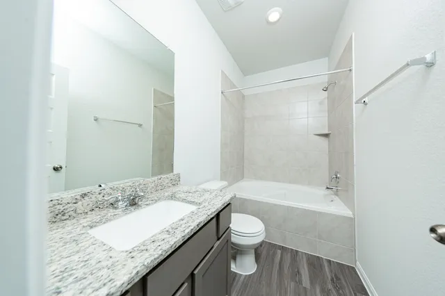 a bathroom with a granite countertop sink toilet and shower