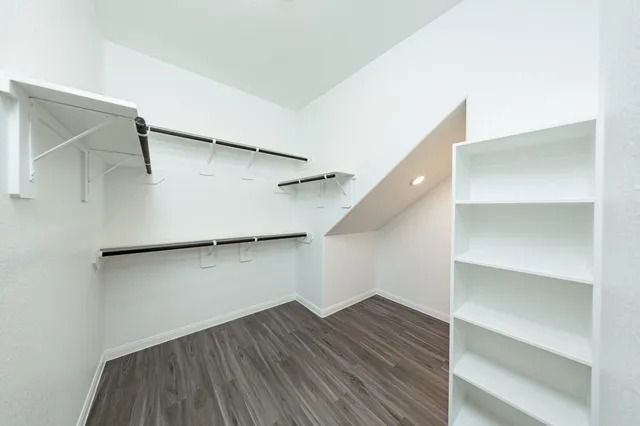 a view of walk in closet with empty racks