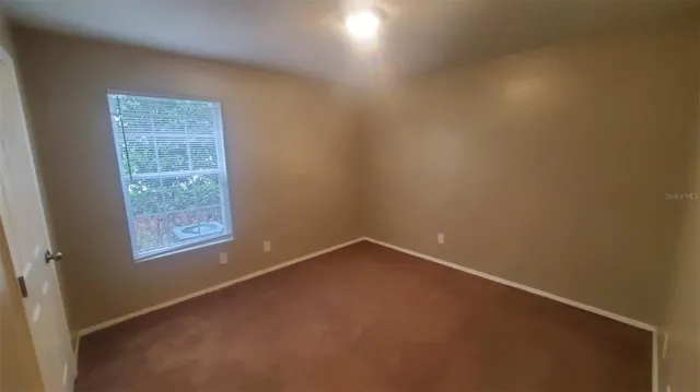 a sign that is sitting on a brick wall with plants