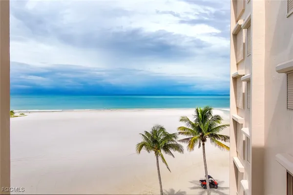 a view of a balcony with chairs and potted plants