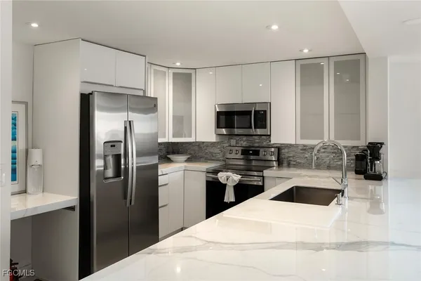 a kitchen with stainless steel appliances kitchen island granite countertop a table and chairs