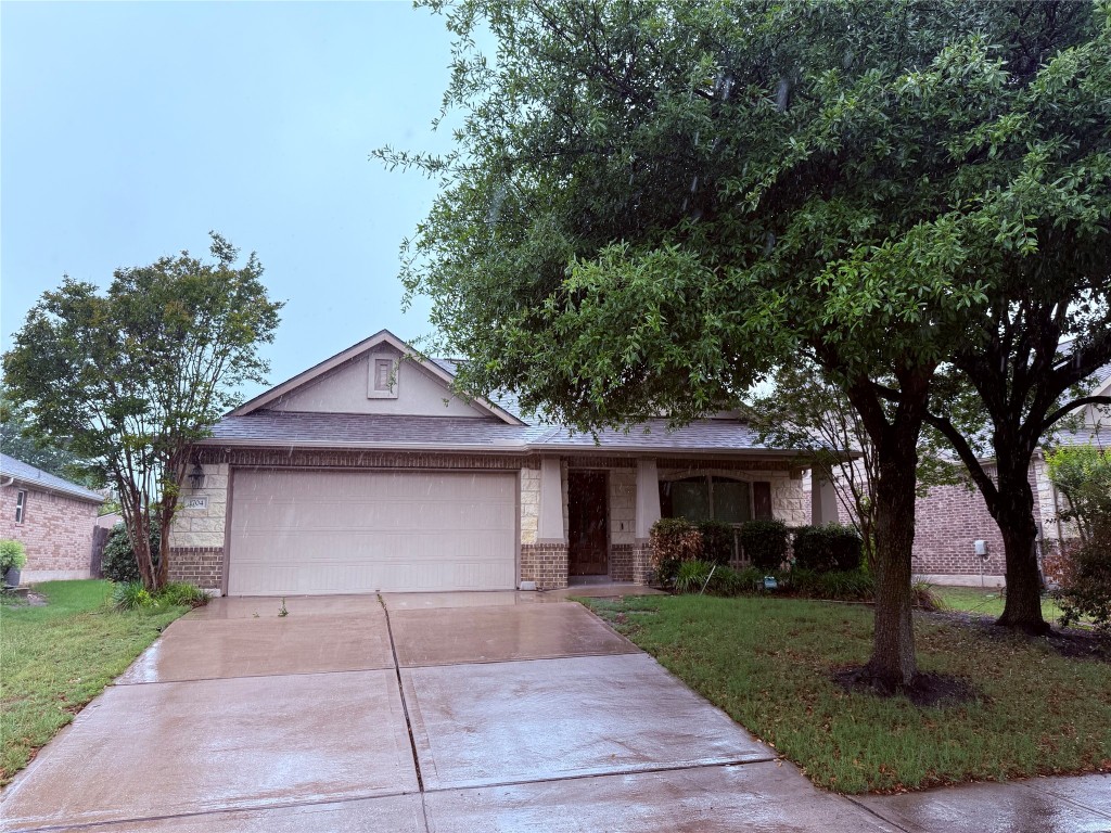 a front view of a house with a garden and trees