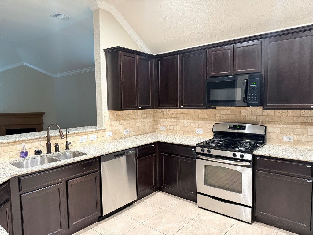 1704 Tranquility Lane Pflugerville, TX 78660 - Photo 17 of 19 a kitchen with granite countertop a sink and steel appliances