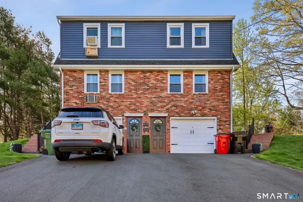 a view of a car parked in front of a brick house