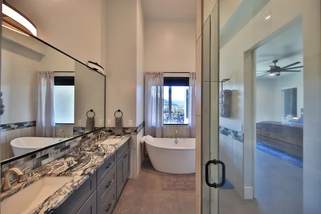 a spacious bathroom with a tub sink and mirror