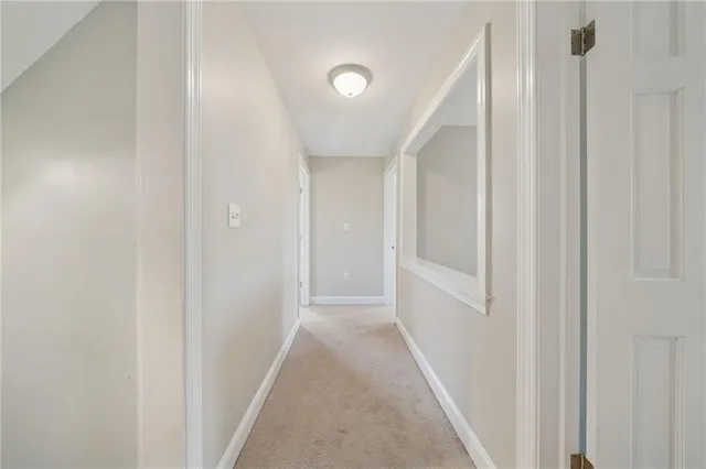 a view of an empty room and kitchen