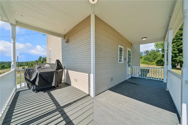 a view of a balcony with chairs and wooden floor