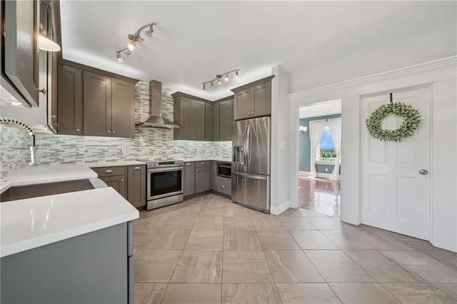 a large white kitchen with a large window and stainless steel appliances