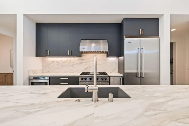 a view of kitchen with stainless steel appliances granite countertop cabinets and wooden floor
