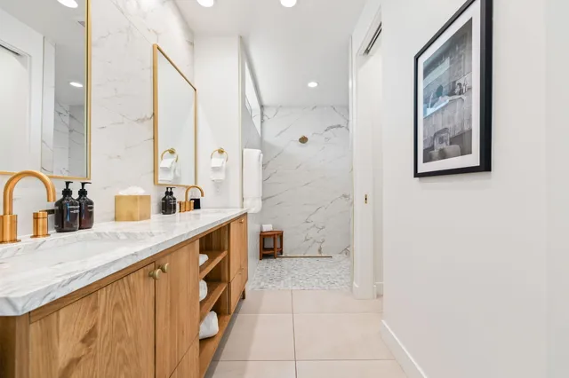a spacious bathroom with a double vanity sink a mirror and a shower