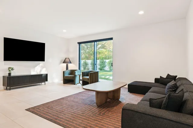 a view of a swimming pool with chairs and table in the patio