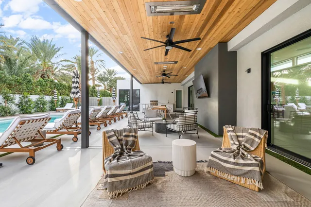 a swimming pool with chairs and table in a patio