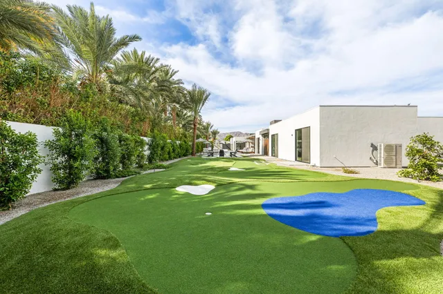 a living room with patio furniture and a rug