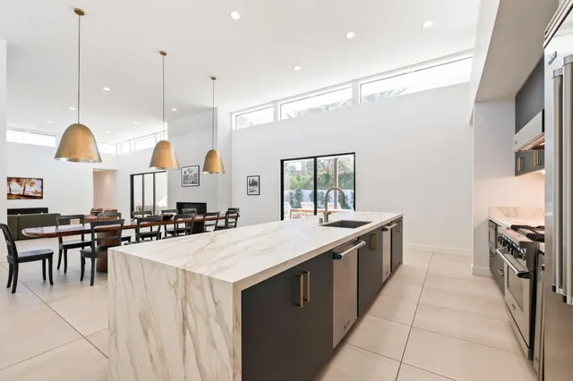 a kitchen with a stove a refrigerator and chairs