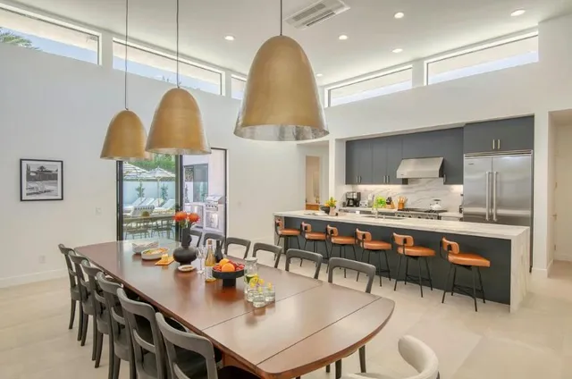 a kitchen with stainless steel appliances a dining table and chairs