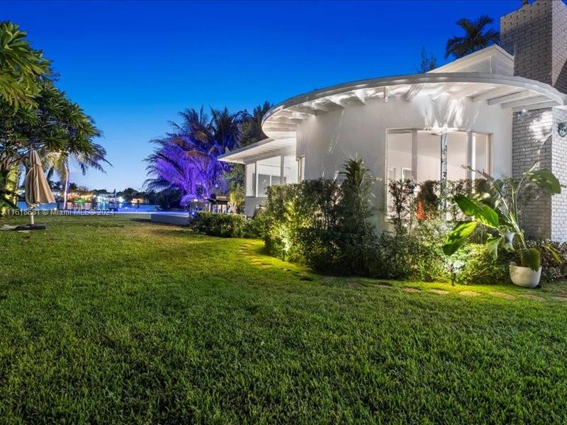 900 88th Street Surfside, FL 33154 - Photo 3 of 60 a front view of a house with garden