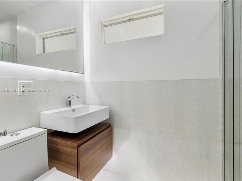 900 88th Street Surfside, FL 33154 - Photo 31 of 60 a utility room with sink dryer and washer