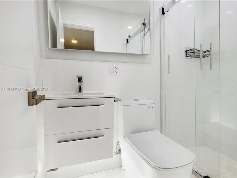 900 88th Street Surfside, FL 33154 - Photo 34 of 60 a bathroom with a toilet a sink and mirror