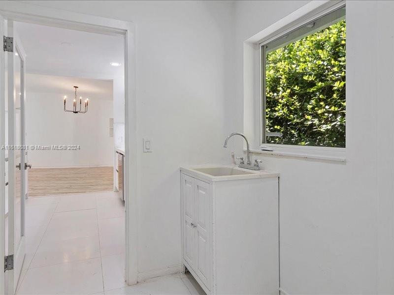 900 88th Street Surfside, FL 33154 - Photo 37 of 60 a bathroom with a sink mirror and window