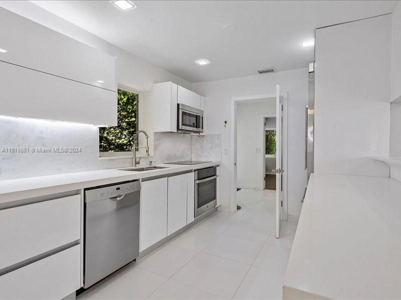 900 88th Street Surfside, FL 33154 - Photo 39 of 60 a kitchen with granite countertop a sink and cabinets