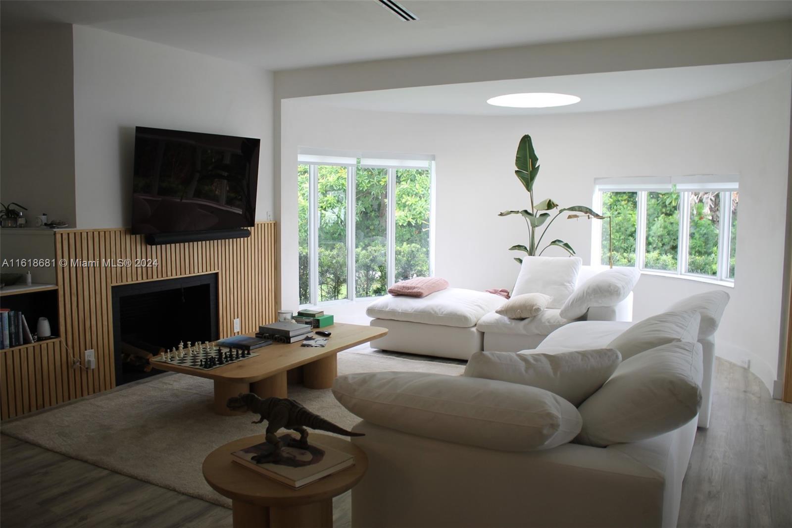 900 88th Street Surfside, FL 33154 - Photo 48 of 60 a living room with furniture a fireplace and a flat screen tv