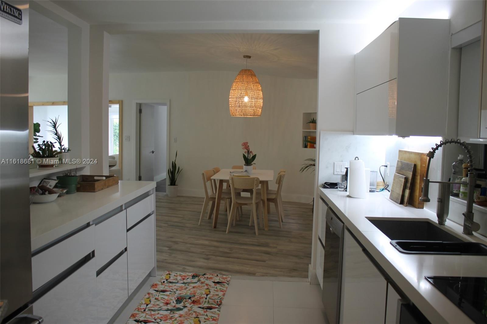 900 88th Street Surfside, FL 33154 - Photo 51 of 60 a kitchen with kitchen island granite countertop a sink a counter space and appliances