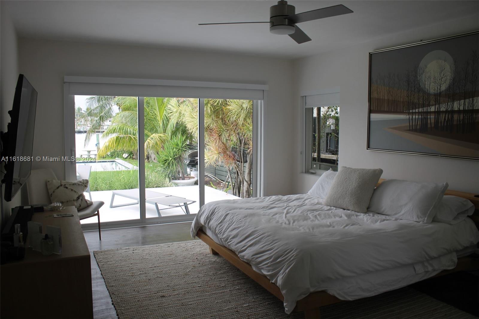900 88th Street Surfside, FL 33154 - Photo 59 of 60 a large bedroom with a bed and glass door