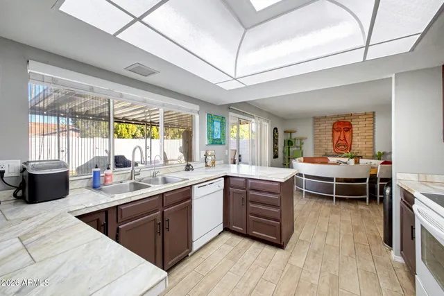 a kitchen with stainless steel appliances granite countertop a sink and wooden floors