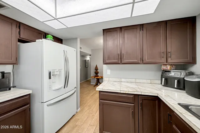 a kitchen with stainless steel appliances a refrigerator a sink and white cabinets