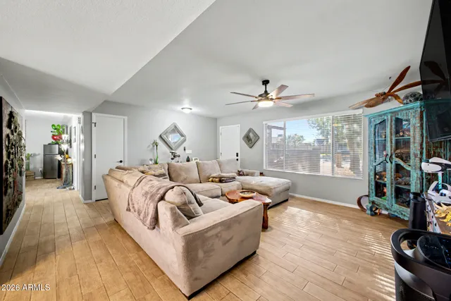 a living room with furniture ceiling fan and a window