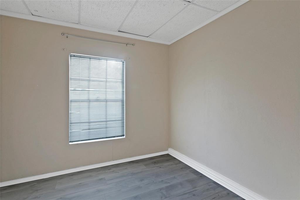 6104 Kelly Elliott Road Arlington, TX 76001 - Photo 21 of 25 an empty room with wooden floor and windows