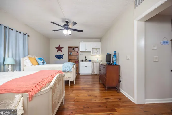 a spacious bedroom with a bed a lamp and a rug