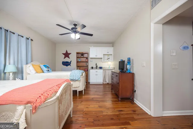 a spacious bedroom with a bed a lamp and a rug