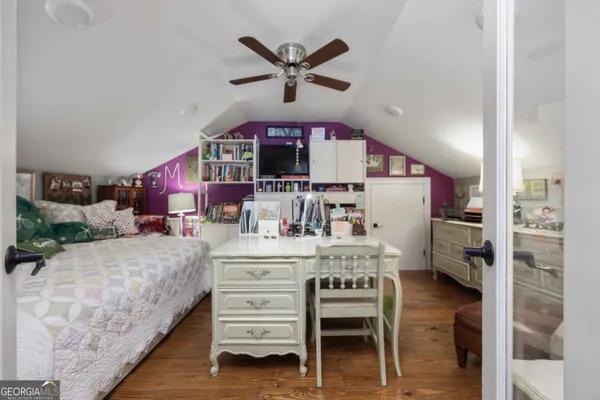 a kitchen with a refrigerator a stove a microwave oven a sink dishwasher and white cabinets with wooden floor