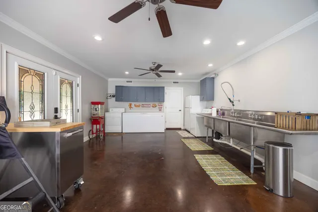 a dining hall with stainless steel appliances granite countertop a couch and a dining table with wooden floor