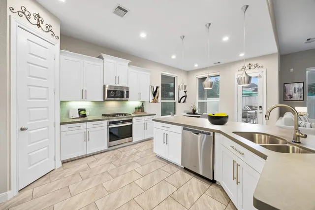 a kitchen with stainless steel appliances granite countertop a sink and a stove