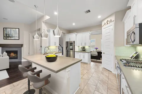 a kitchen with white cabinets and appliances