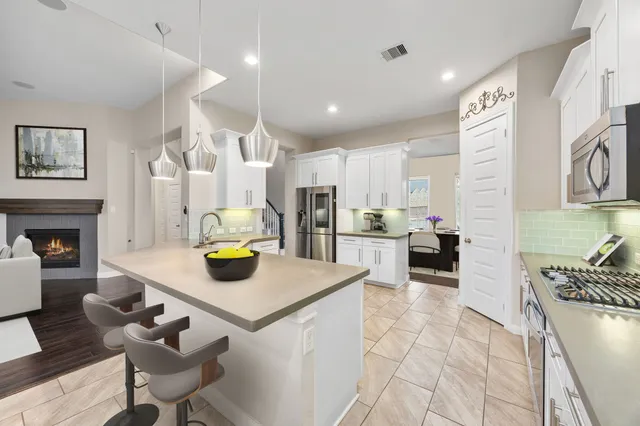 a kitchen with white cabinets and appliances