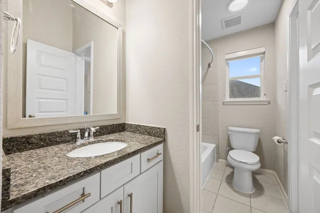 a bathroom with a granite countertop sink and a mirror a bathtub