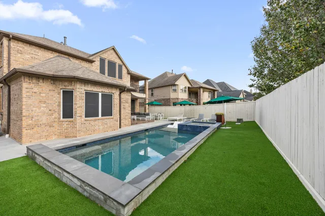 swimming pool with outdoor seating and yard