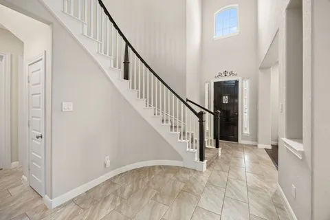 a view of staircase with railing and white walls