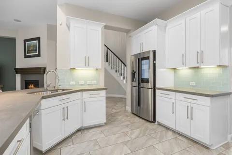 a kitchen with stainless steel appliances granite countertop a sink and dishwasher a stove top oven with white cabinets