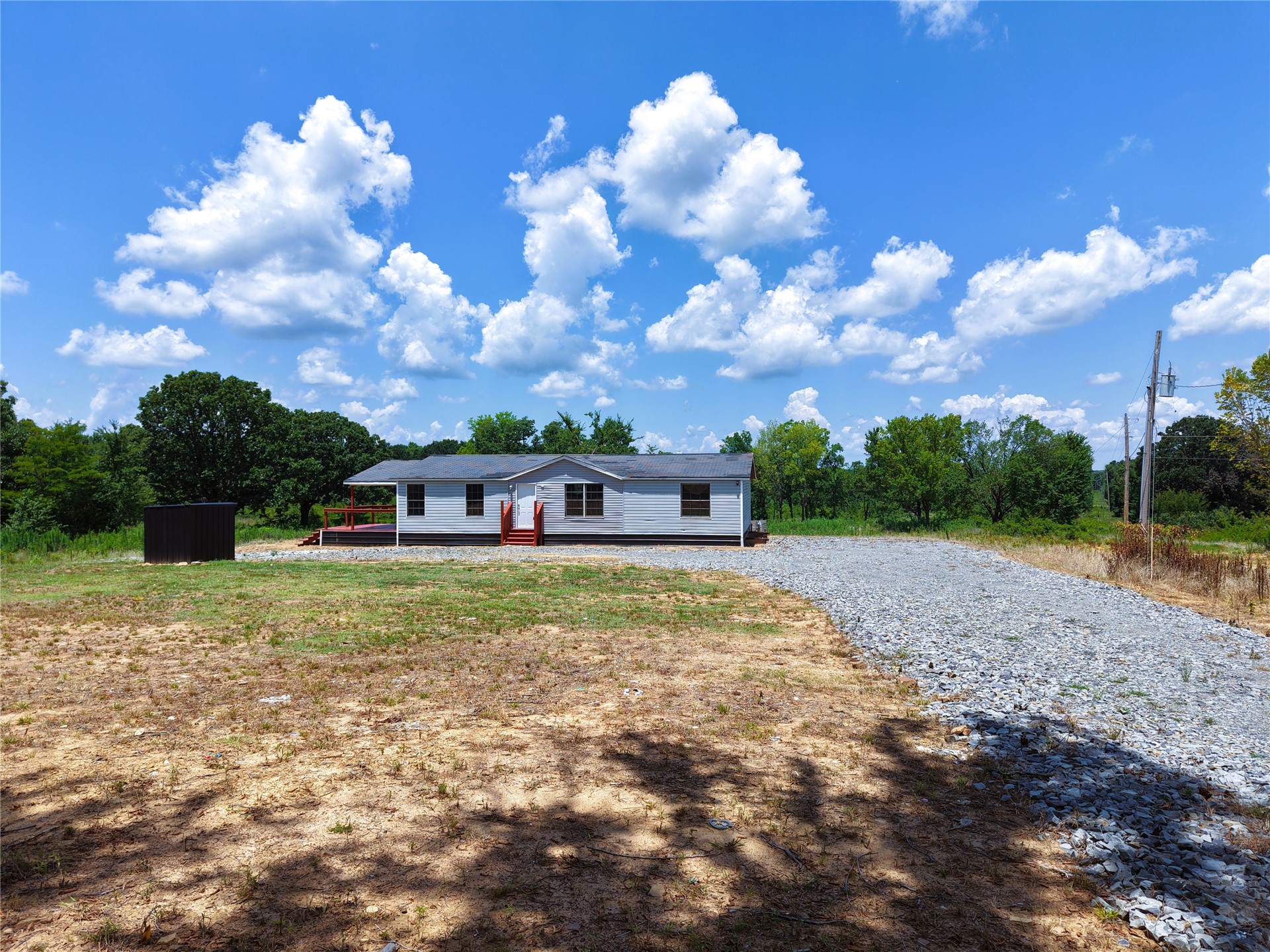 33594 Johnson Shady Point Shady Point, OK 74956 - Photo 1 of 18 Single-story residence with a covered porch, white exterior siding, and a gravel driveway