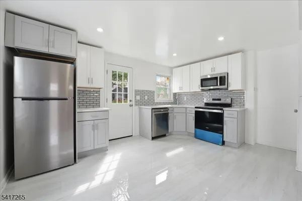 a kitchen with a refrigerator a sink and a microwave