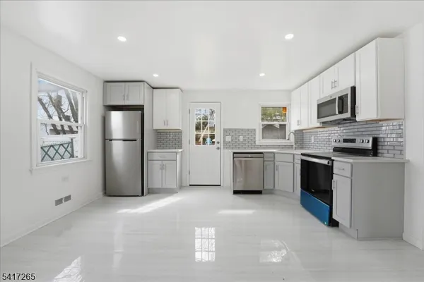 a kitchen with stainless steel appliances a refrigerator sink and cabinets