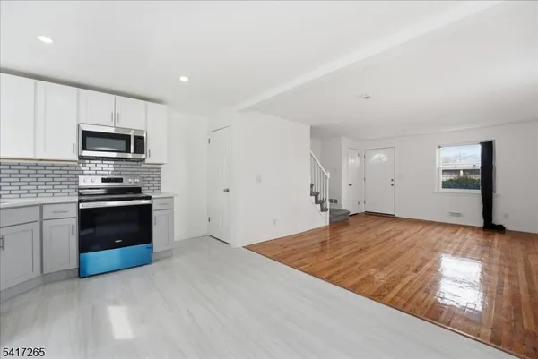 a kitchen with kitchen island granite countertop a stove and a sink