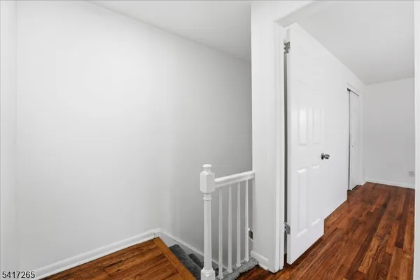 a view of a hallway with wooden floor and closet
