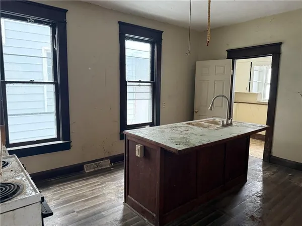 a kitchen with a stove and a wooden floor