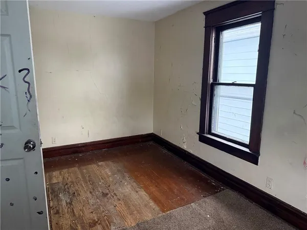 a view of a small space with wooden floor and a window