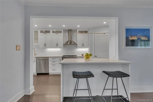 a kitchen with stainless steel appliances granite countertop a lot of counter space and wooden floors